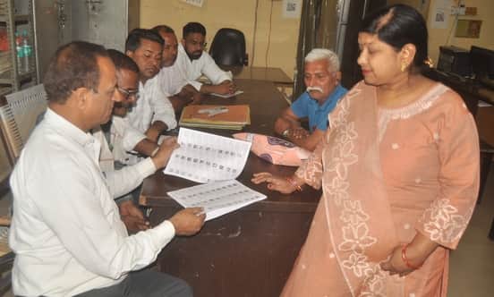 नगर पालिका में महिला को मतदाता सूची दिखाते बीएलओ। संवाद