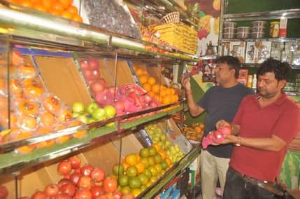 रेलवे रोड स्थित फल की दुकान से विदेशी फल खरीदते युवक। संवाद