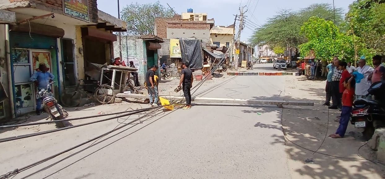 Power pole falls on road from wires tangled in pickup