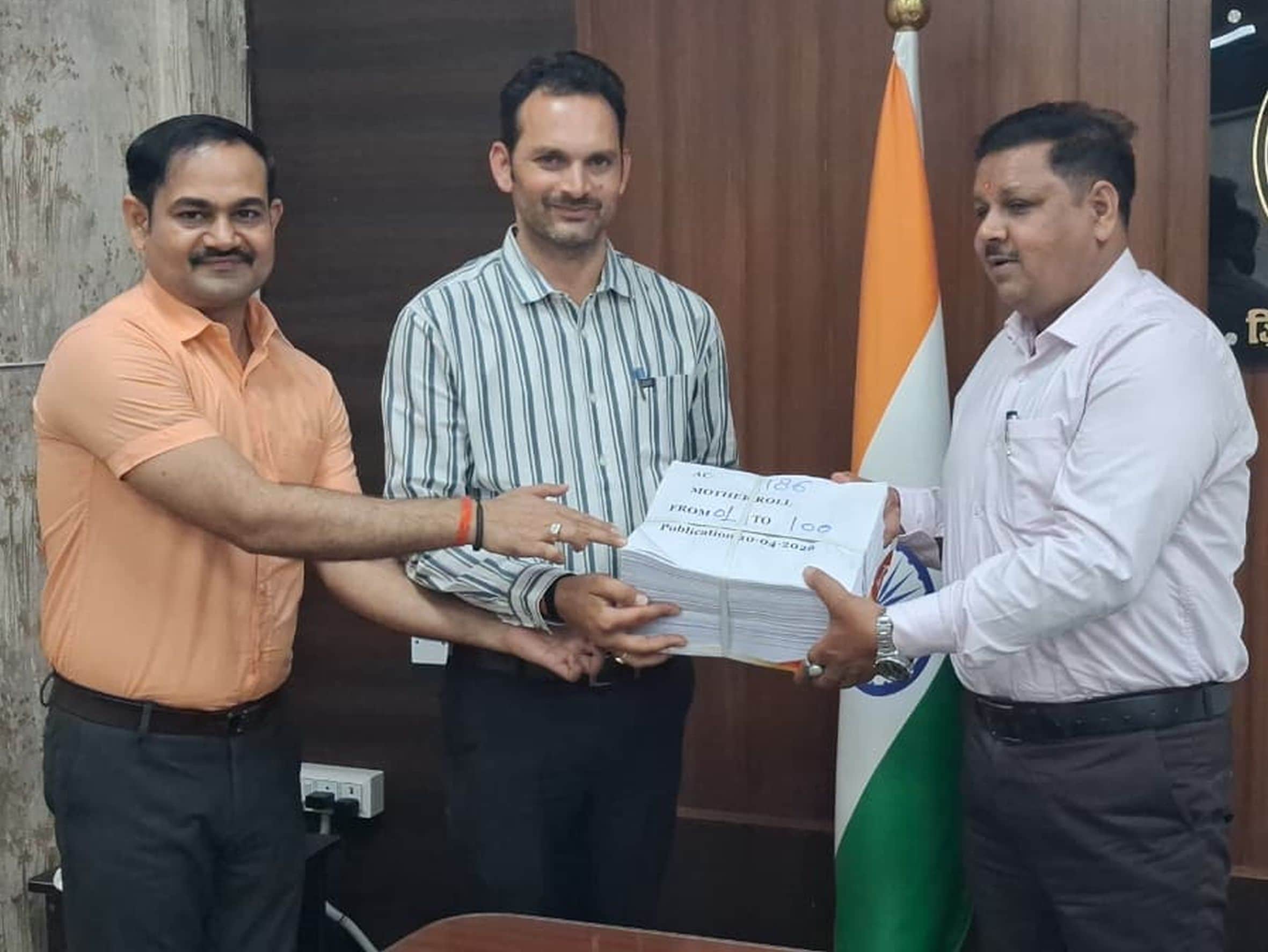 मतदाता सूची प्रकाशित होने उसकी कापी के बंडल को कर्मी को सौपते डीएम। सूचना विभाग