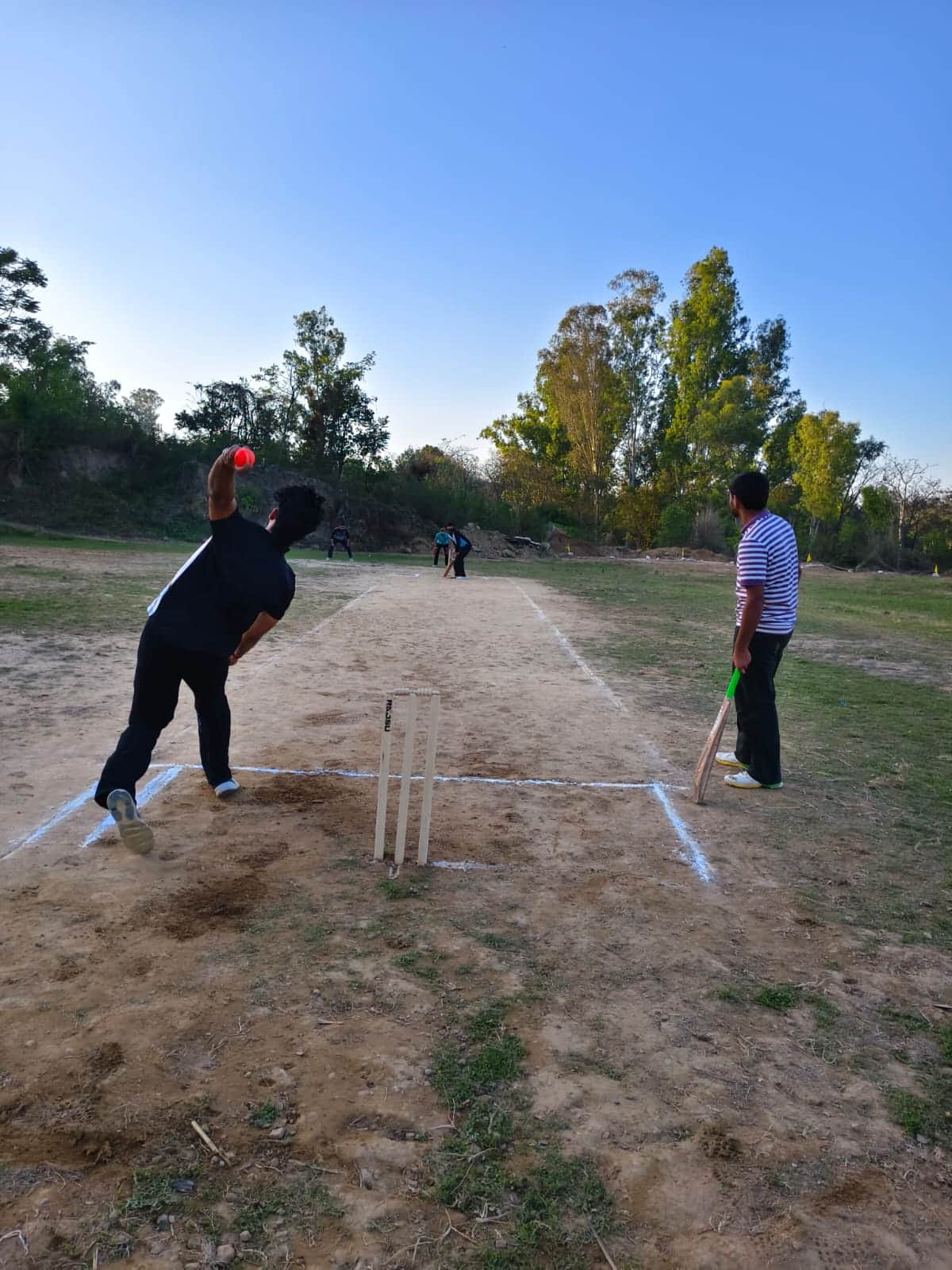 भदरोग में आयोजित क्रिकेट प्रतियोगिता में गेंद करवाता गेंदबाज। संवाद