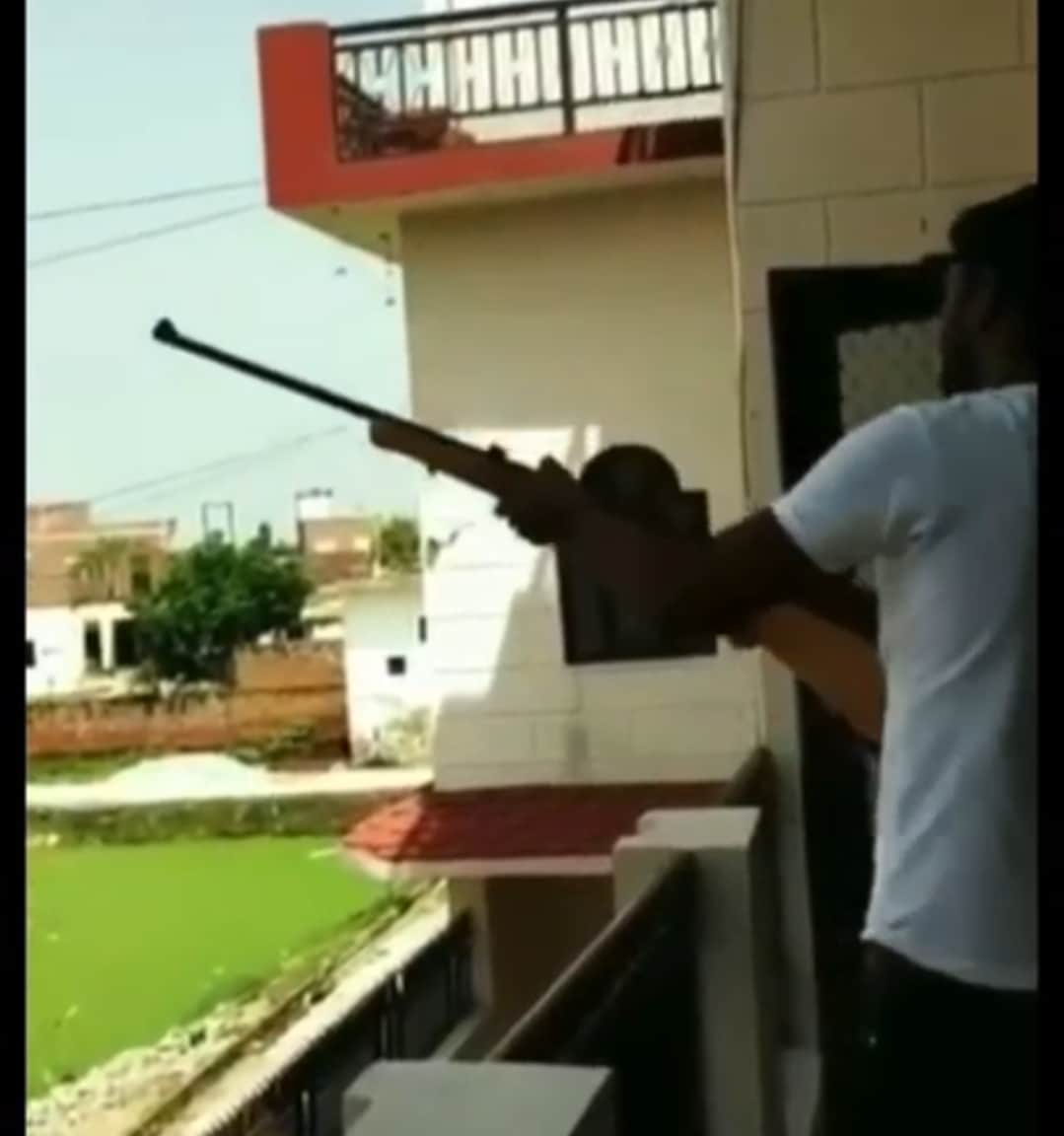 घर पर खड़े होकर फायरिंग करता आरोपी युवक। स्रोत सोशल मीडिया