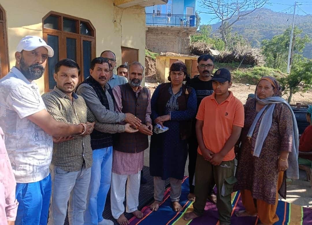 कुरूगनु गांव में मृतक चालक के परिवार को सहयोग राशि देते मोटर चालक संघ के पदाधिकारी। स्रोत: संघ