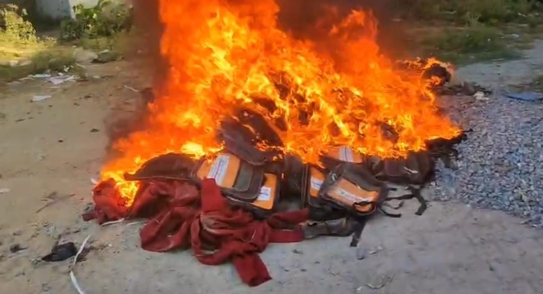 50 school bags with 'Right to Education' written on them were burnt after placing them on a garbage heap.