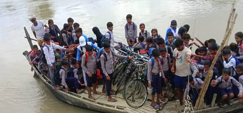 नाव से नदी पार करते बच्चे । 