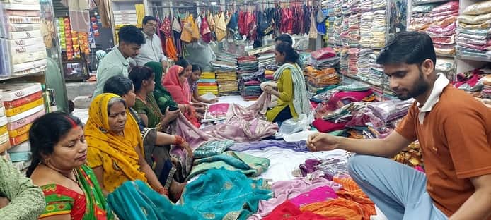 पडरौना शहर में कपड़े की दुकान पर साड़ी की खरीदारी करतीं महिलाएं। संवाद