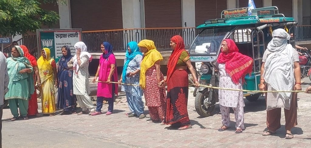 Women blockade the road and surround Energy Corporation officials in protest against prepaid meters.