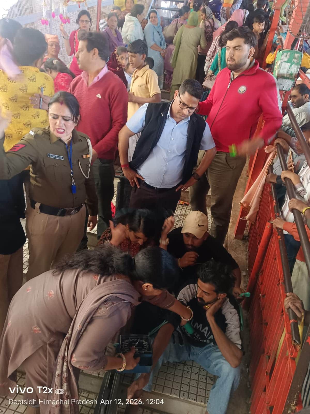 : बाबा बालक नाथ मंदिर में कतार में लगे श्रद्धालु की तबीयत बिगड़ने पर उपचार देते चिकित्सक। स्रोत