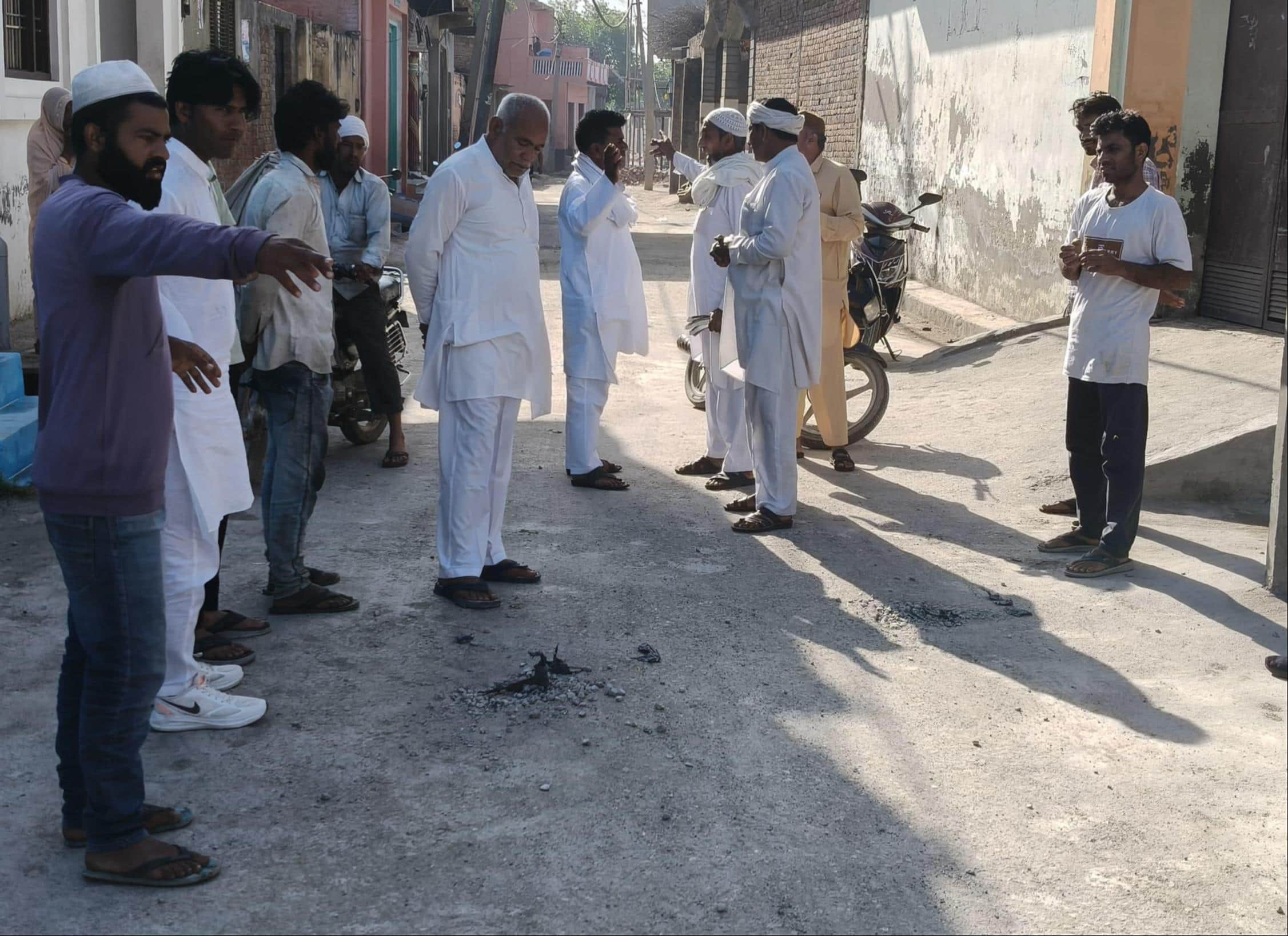 कांधला के गढी मियां में उखड़ी सड़क को लेकर मौके पर मौजूद ग्रामीण। संवाद