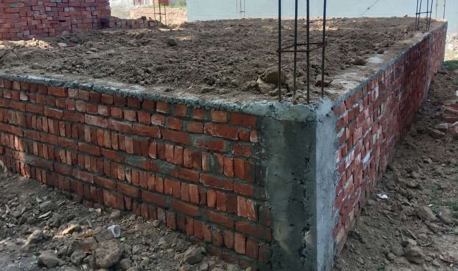 पीएम आवास योजना में बन रहे मकान की नींव के ऊपर बीम की जगह डाली गई डीपीसी