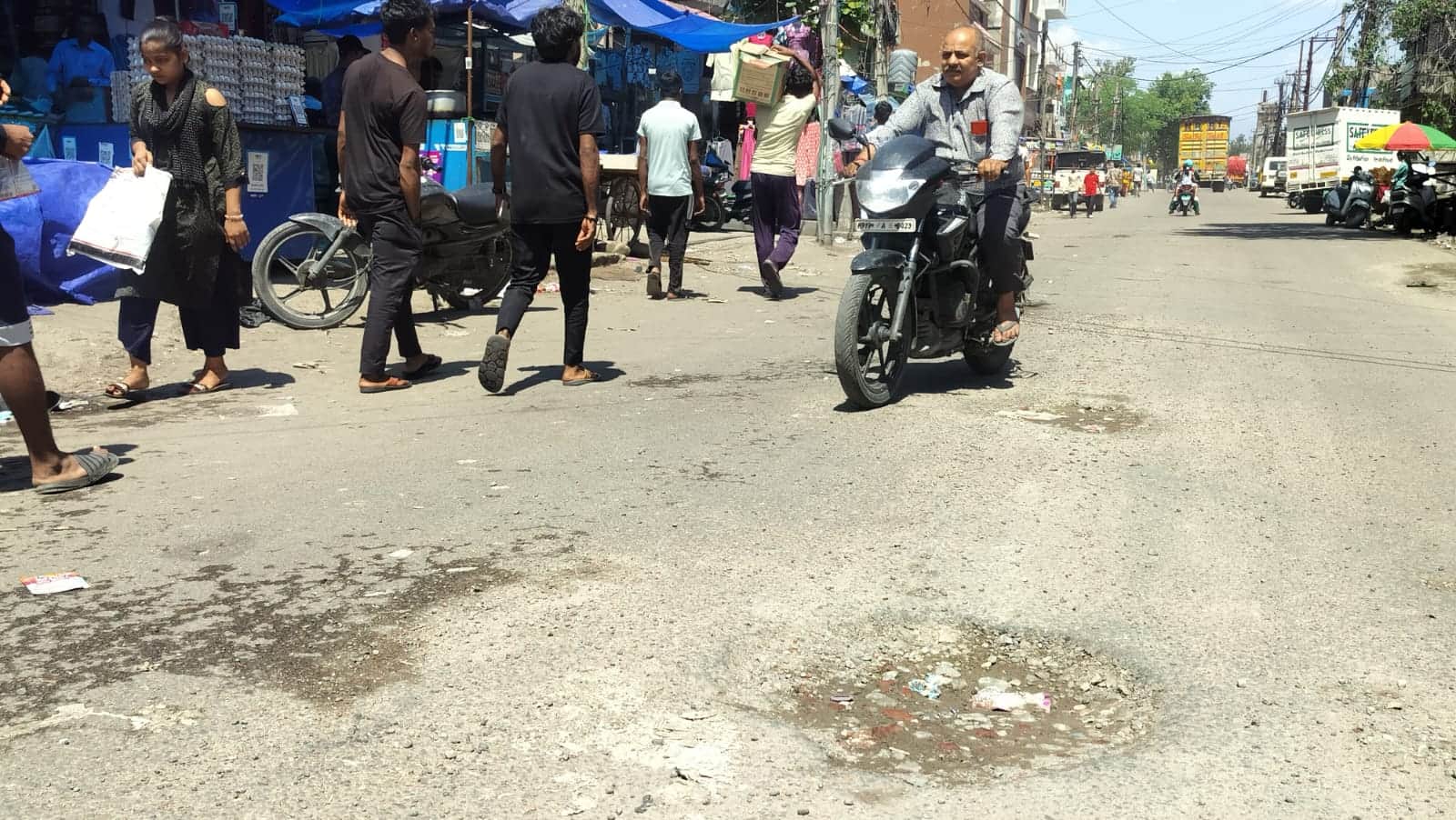 रेलवे रोड पर जगह-जगह बने गड्ढों के बीच से गुजरते वाहन चालक। संवाद