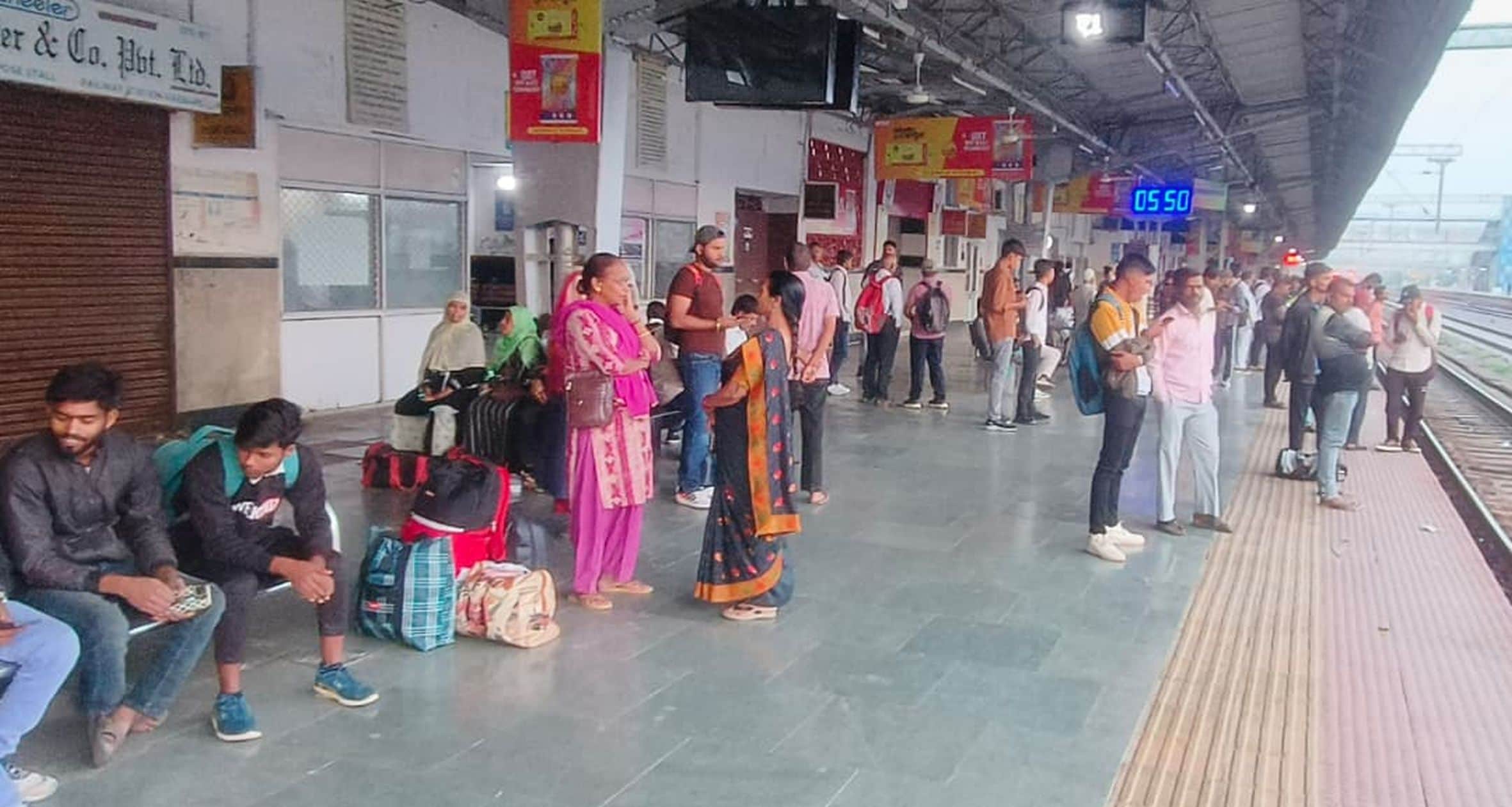 रेलवे स्टेशन के प्लेटफार् एक पर सुबह ट्रेन के आने का इंतजार करते यात्री। 