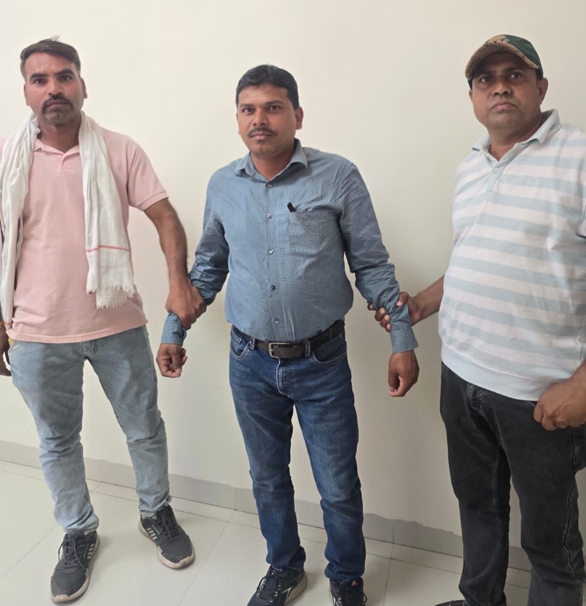 आरोपी पटवारी कैलाश वडक्या को पकड़कर खड़े लोकायुक्त टीम के सदस्य।