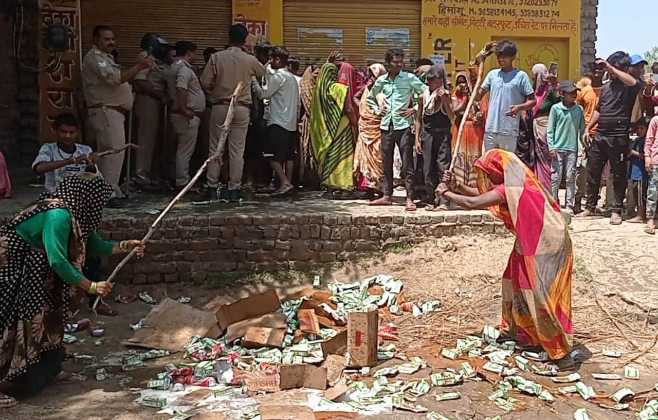 फोटो04सुन्नगढ़ी के गांव बस्तरमऊ में शराब के पौव्वे व बीयर की केन को डंडे से तोड़ती महिलाएं। स