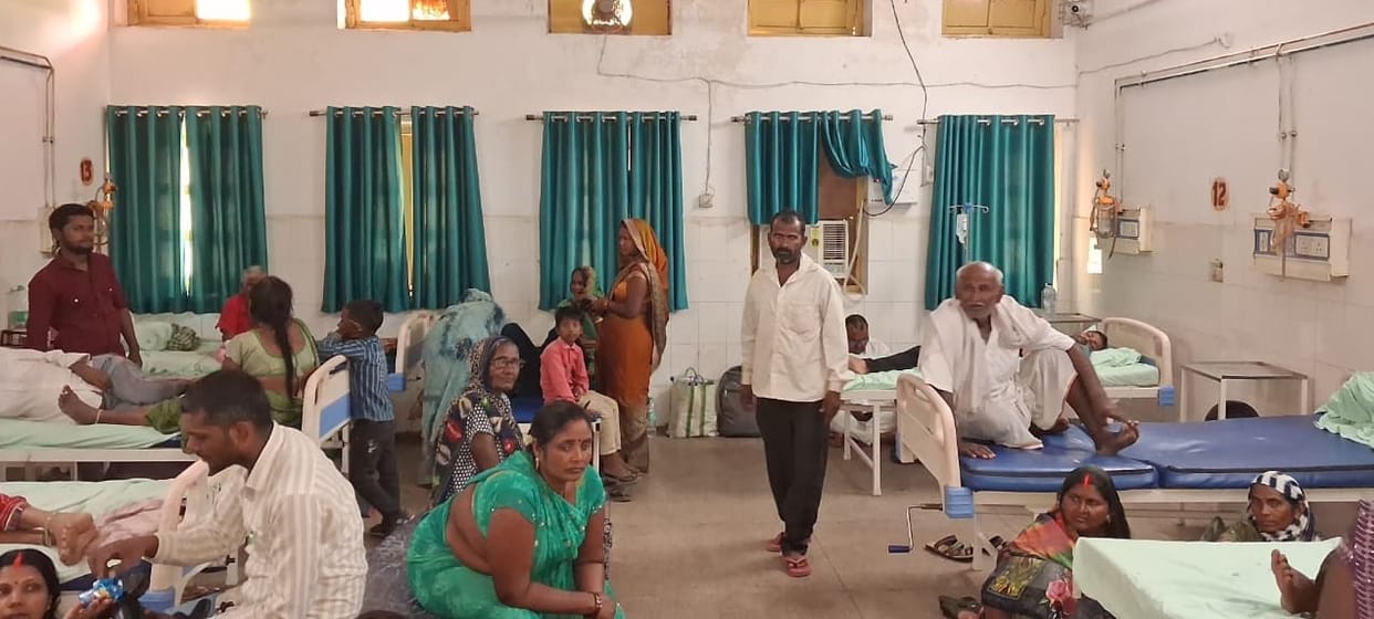 A 'cool' health department in a sweltering district, with normal patients in heatwave wards, coolers missing, and fans missing elsewhere.