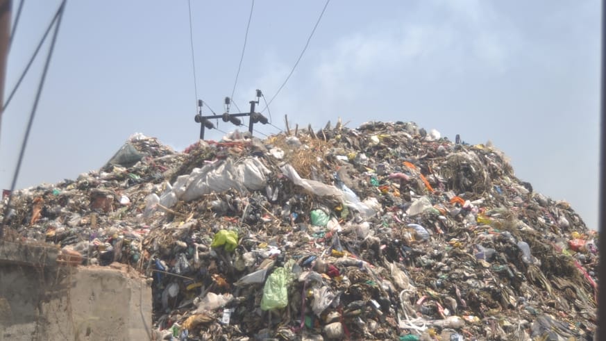High-tension line poles are being buried under heaps of garbage, increasing the risk of accidents.