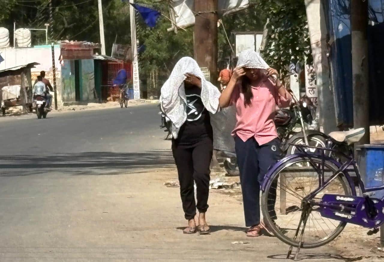 ज्ञानपुर नगर में तिखी धूप से बचाव के लिए सर को ढक कर जाती युवतियां।