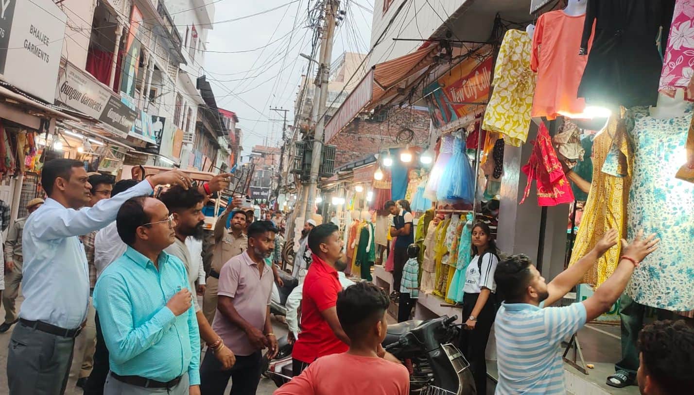 कोटद्वार के गंगादत्त जोशी मार्ग पर सड़क पर रखे सामान को हटवाते नगर आयुक्त पीएल शाह व एसडीएम संद