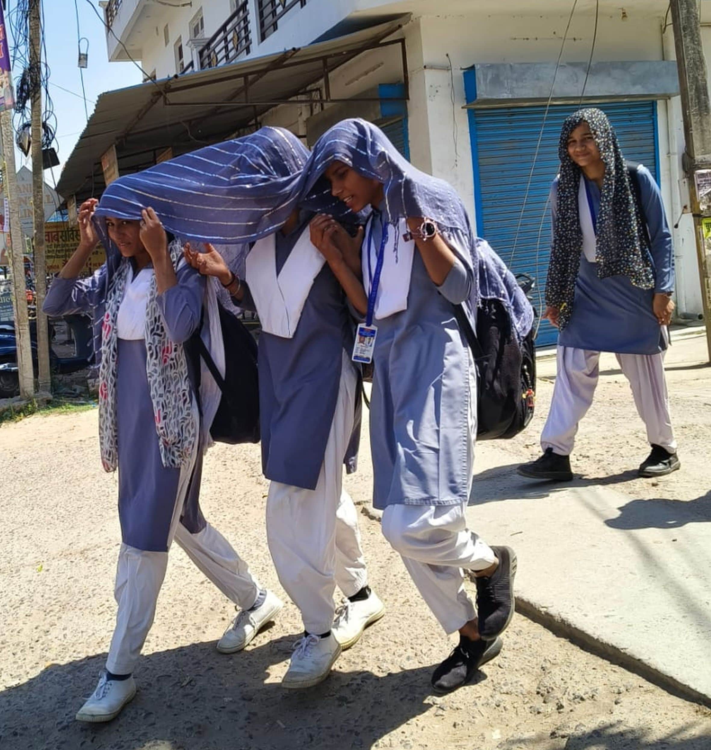 अमेठी कस्बे में स्टाॅल ओढ़ धूप से बचाव कर जाती छात्राएं। संवाद  
