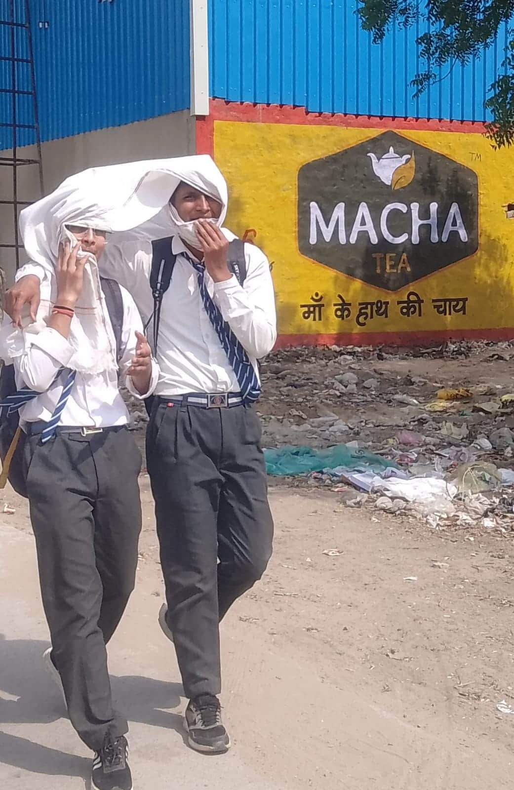 फोटो नंबर- 30धूप से बचाव के लिए सिर पर तौलिया रखकर घर जाते छात्र। संवाद