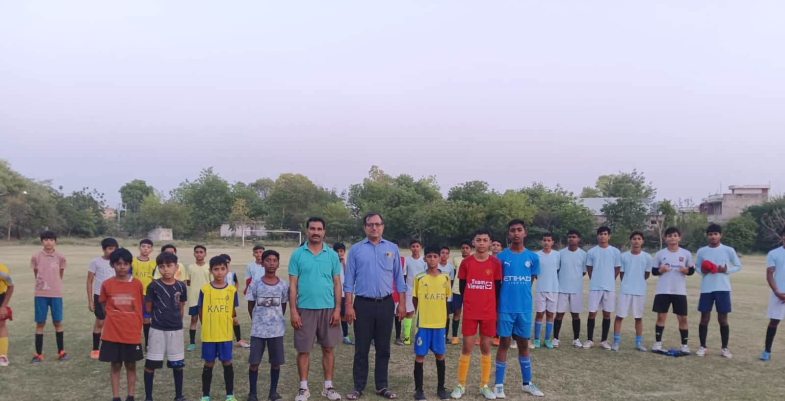 निरीक्षण के दौरान मैदान में एकजुट खिलाड़ी कोच। स्रोत : स्कूल