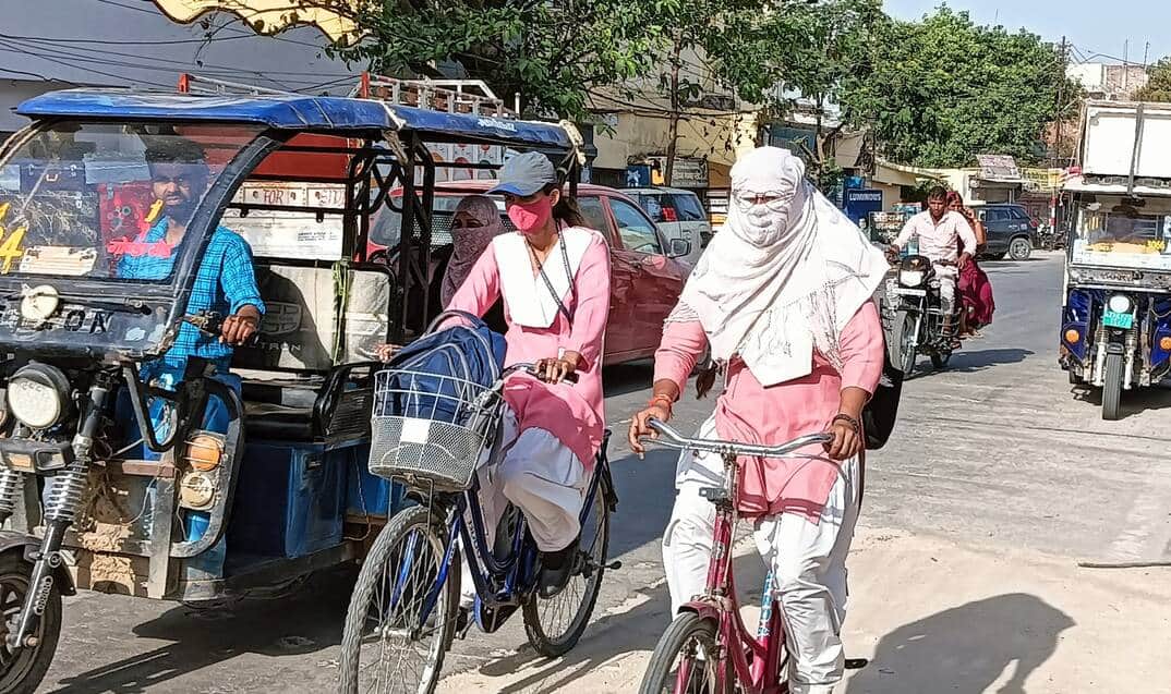 फोटो-27-बलरामपुर के गोंडा रोड पर धूप से बचने के लिए दुपट्टा लपेटकर जाती छात्राएं ।-संवाद