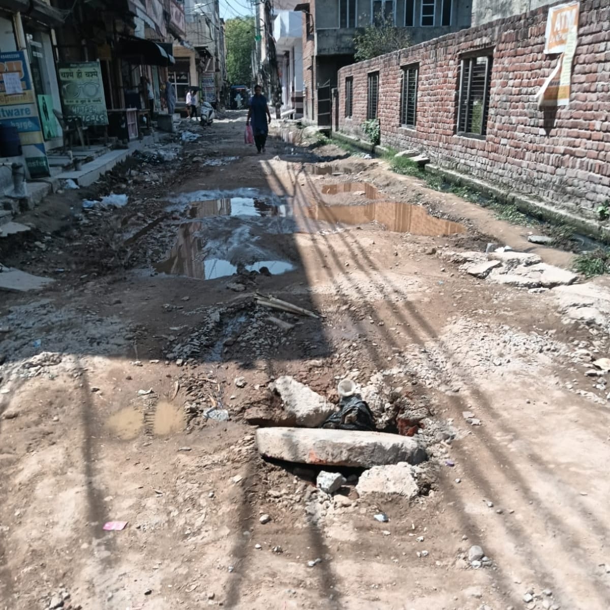 The street in Mahavir Park was dug up and left unfinished; residents are distressed as the debris has not been cleared.