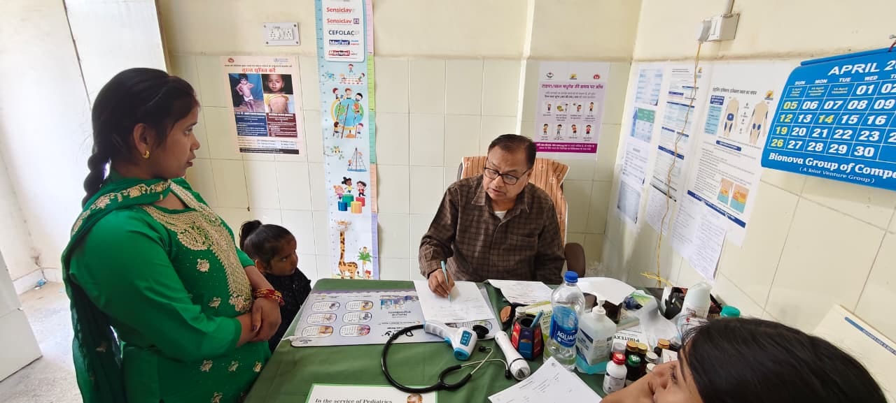 जिला अस्पताल में बच्चे की जांच के बाद दवा लिखते बाल रोग विशेषज्ञ। संवाद