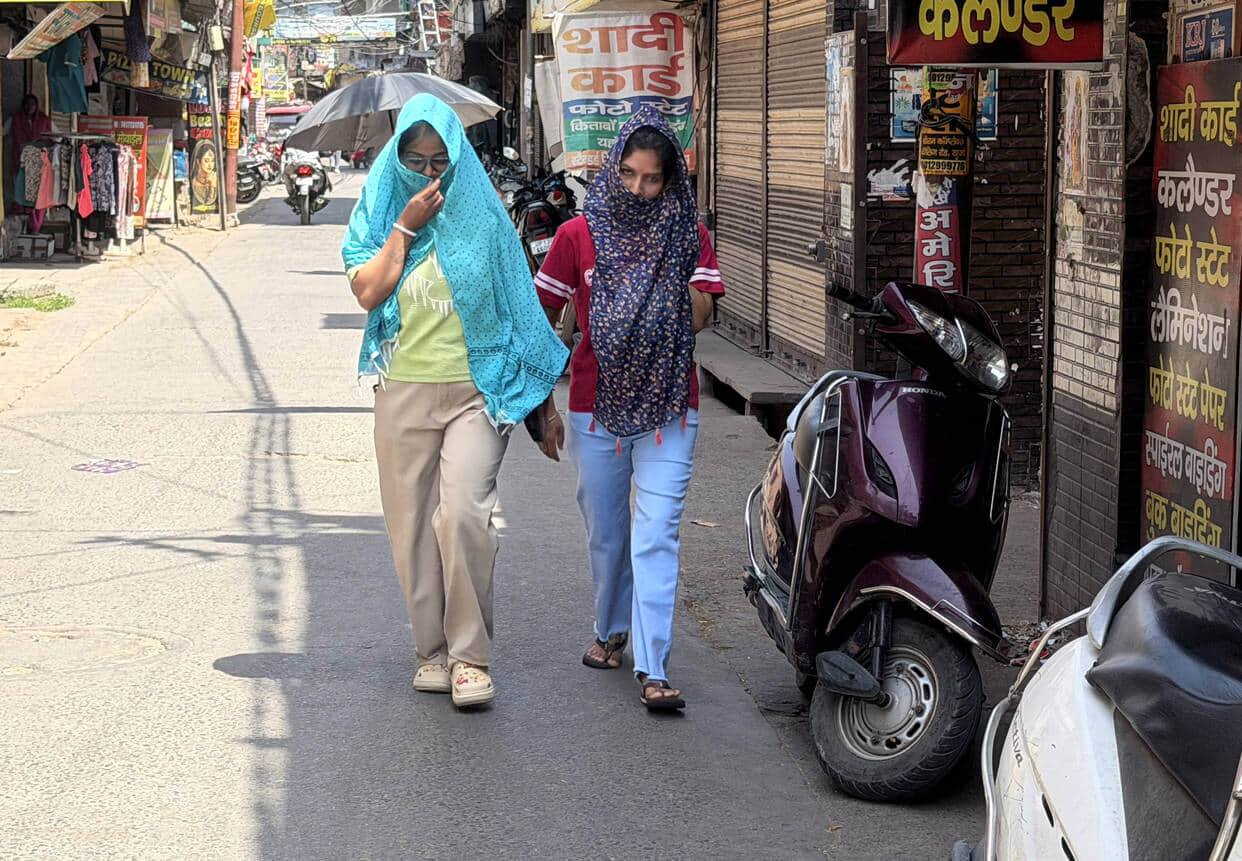खुर्जा के कॉलेज मार्ग पर बुधवार को तेज धूप में चहरा ढककर जातीं युवतियां। संवाद