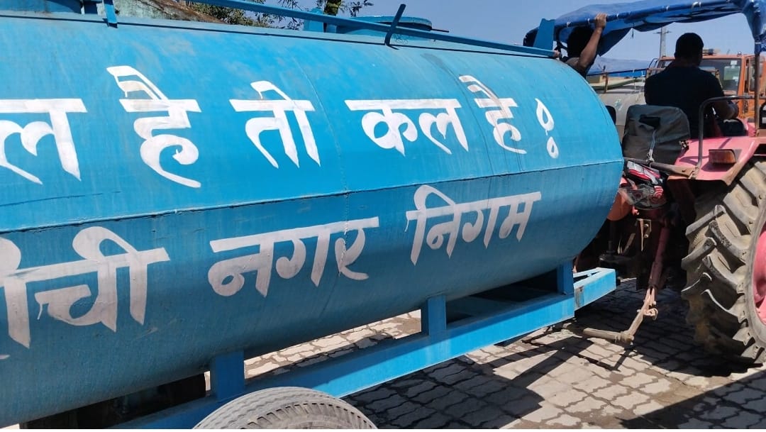 नगर निगम के कर्मी वार्ड में टैंकर के माध्यम से पानी की आपूर्ति करते हुए