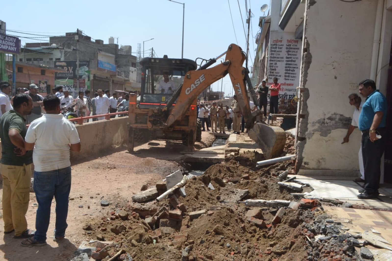 बड़ौत में बिनौली मार्ग स्थित सर्विस रोड  पर जेसीबी मशीन से अतिक्रण हटवाते अधिकारी। संवाद