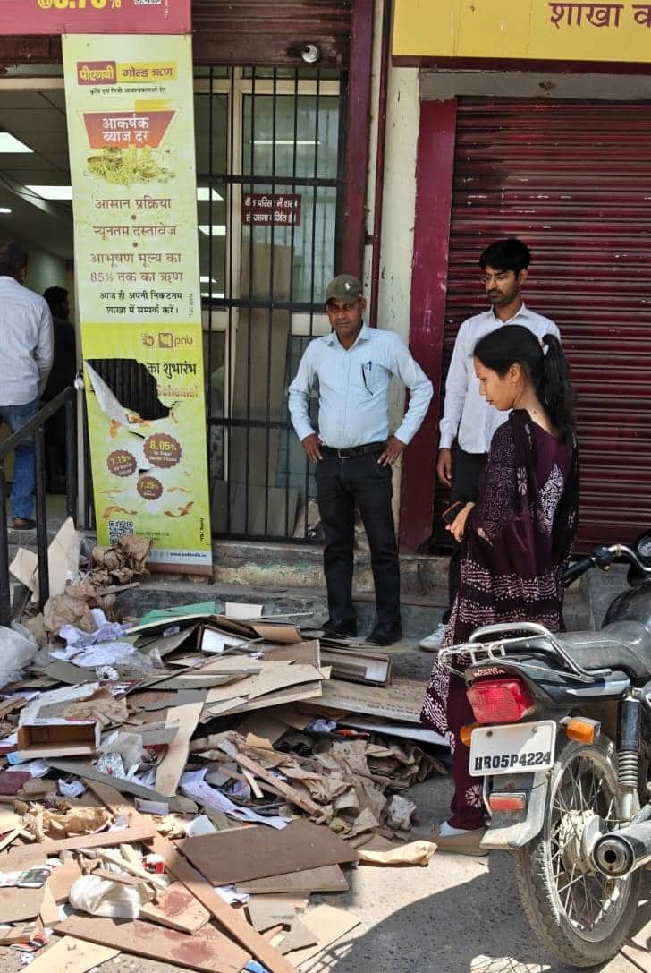 पंजाब नैशनल बैंक के बाहर पड़े कचरे का चालान करते हुए नपा कर्मचारी। प्रवक्ता