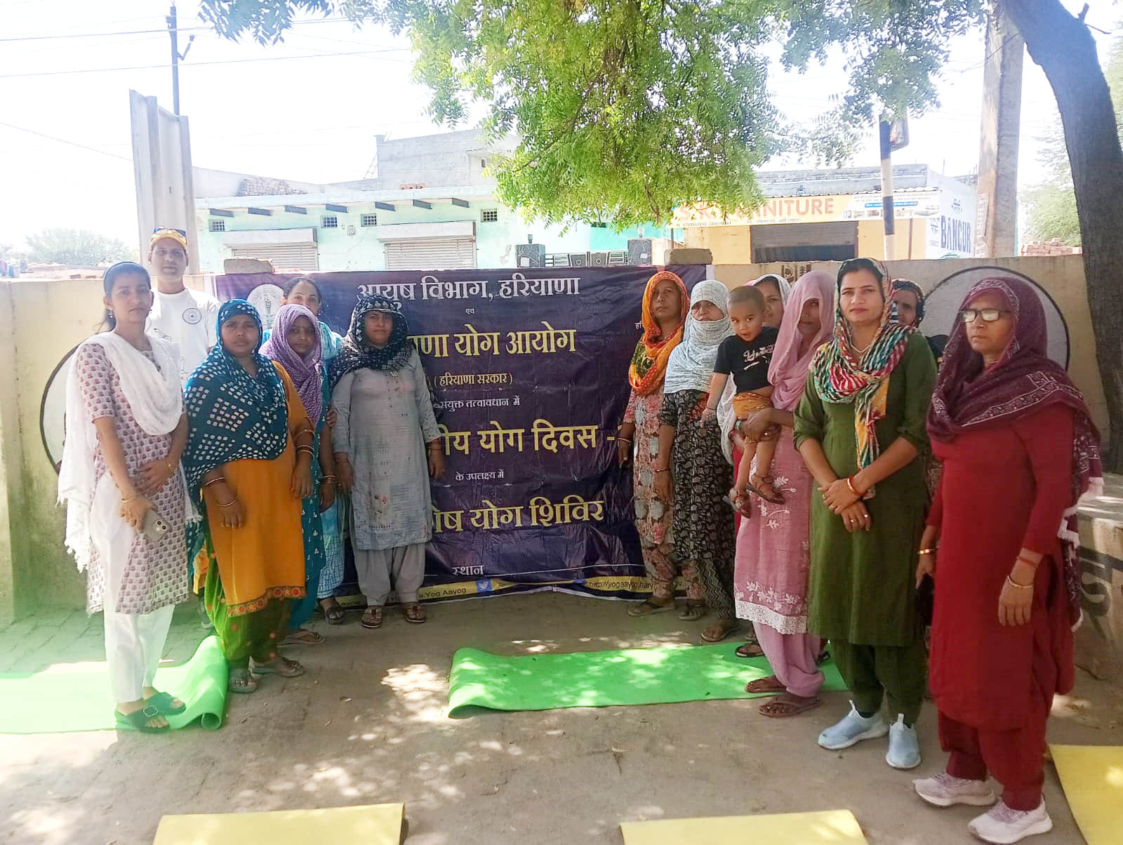 फोटो 01 खेड़ी महम में योग शिविर के अवसर पर मौजूद ग्रामीण महिलाएं व अन्य । स्रोत विभाग