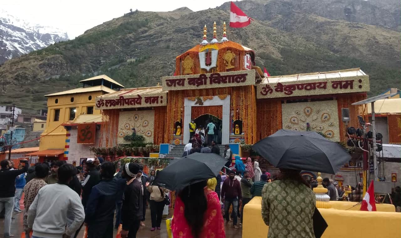 बदरीनाथ में बारिश से बचने के लिए छाते का सहारा लेते श्रद्धालुृगण। स्रोत: जागरुक पाठक 