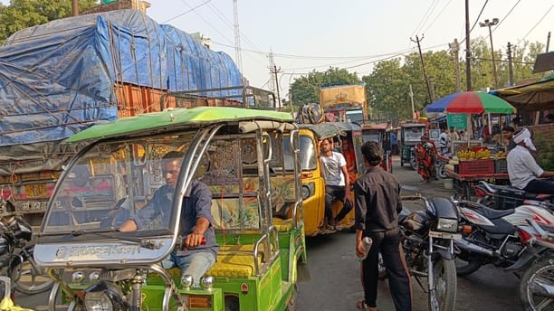 Illegally parked vehicles, haphazardly positioned across the road, obstruct traffic on the highway.