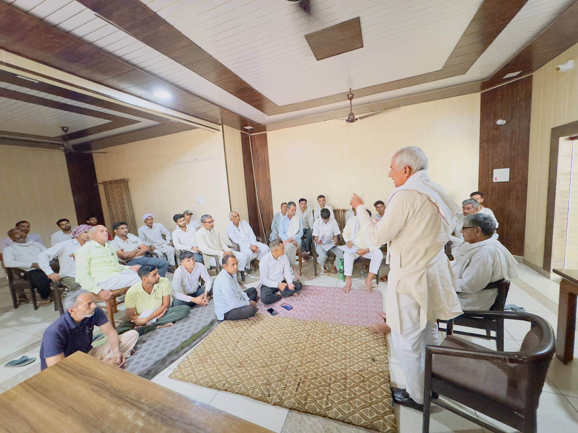 ढिगावा मंडी के किसान विश्राम गृह में उपस्थित किसानों को संबोधित करते वक्ता ।