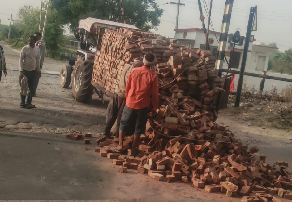 Tractor-trolley overturned, bricks scattered on the road