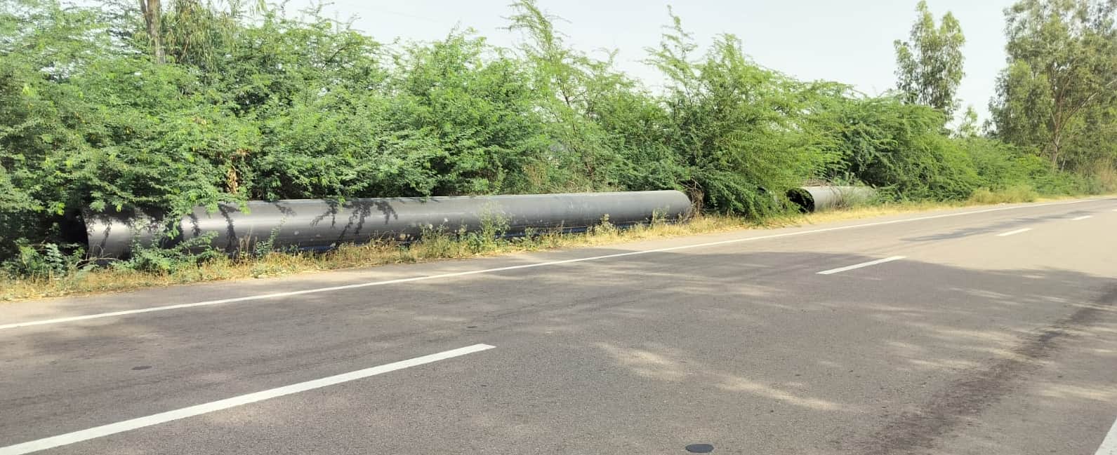 दो साल से सड़क किनारे पड़े बरसाती पानी निकासी के लिए दबाए जाने वाले पाइप।