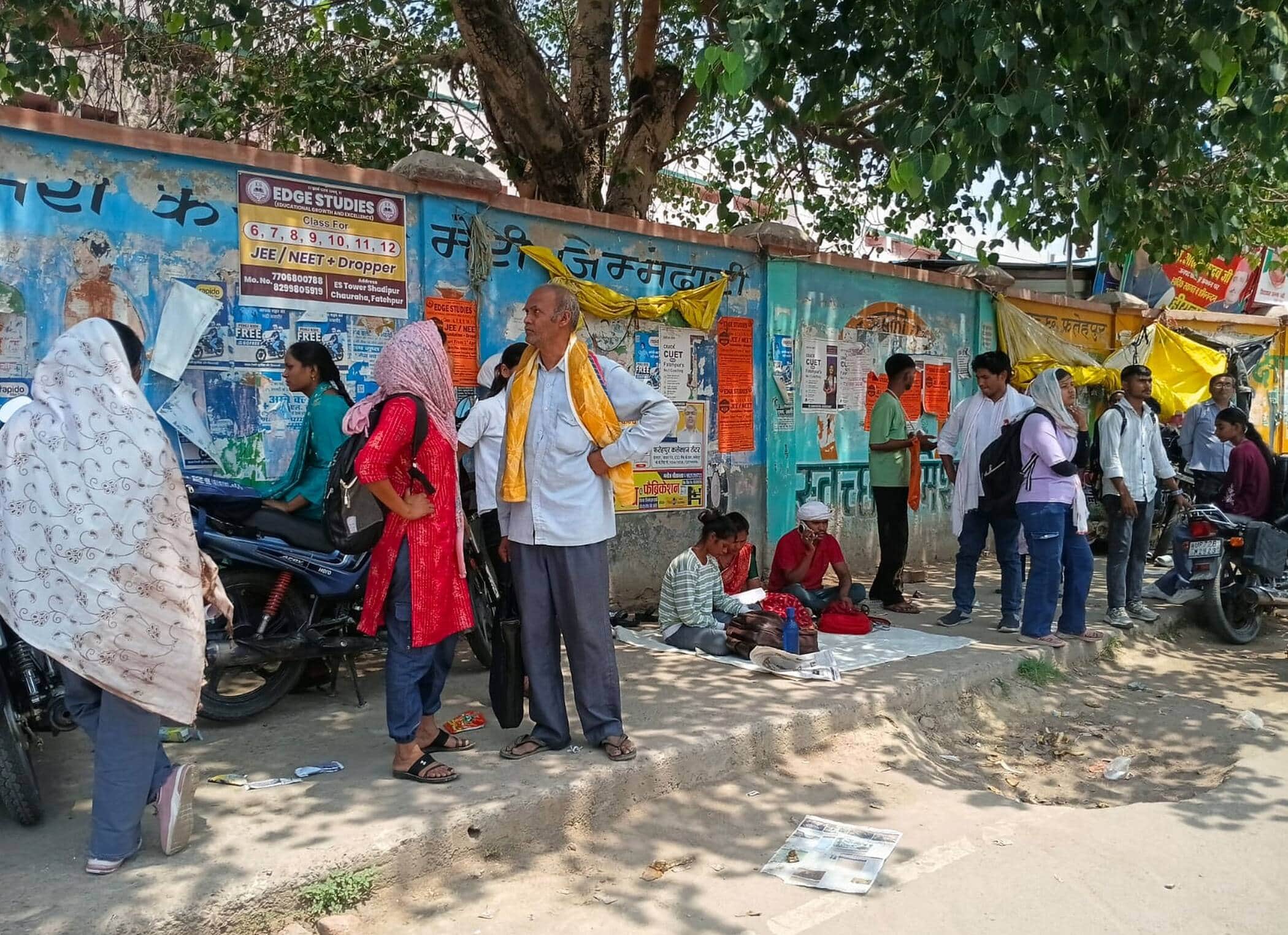 फोटो-30-केंद्र के बाहर कुछ पेड़ की छांव में तो कुछ धूप में खड़े अभ्यर्थी व परिजन।संवाद