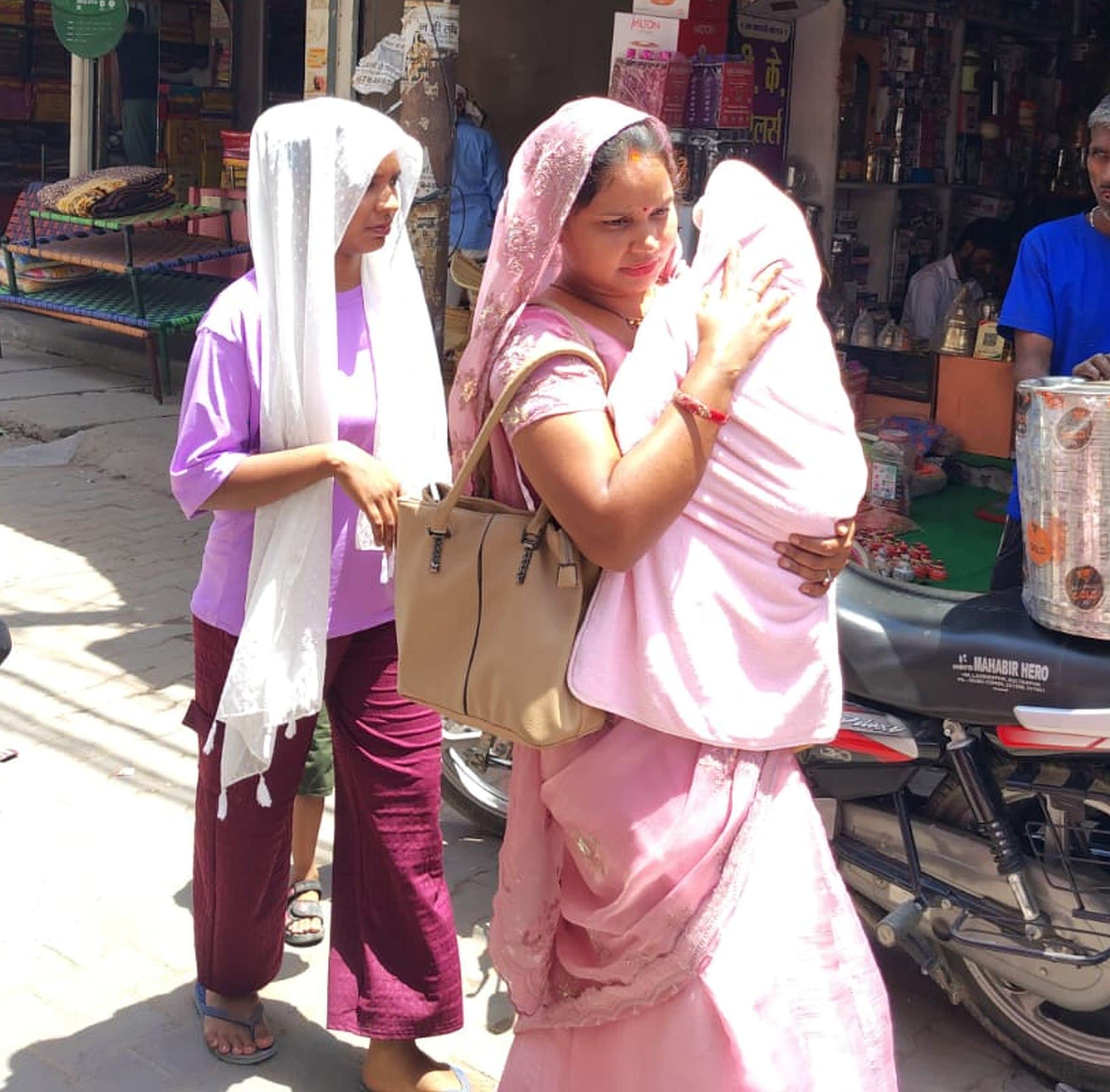 गौरीगंज में रविवार को तेज धूप के दौरान बच्चे का बचाव करती महिला। -संवाद