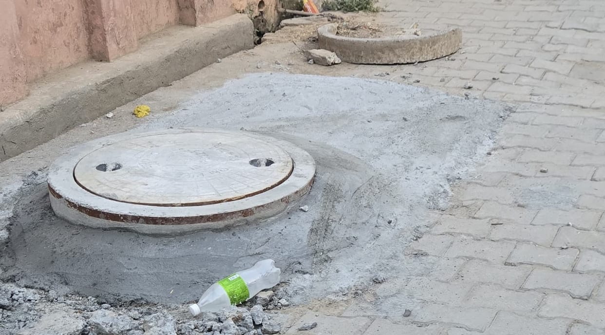 The sewer manhole cover was raised above the level of the road.