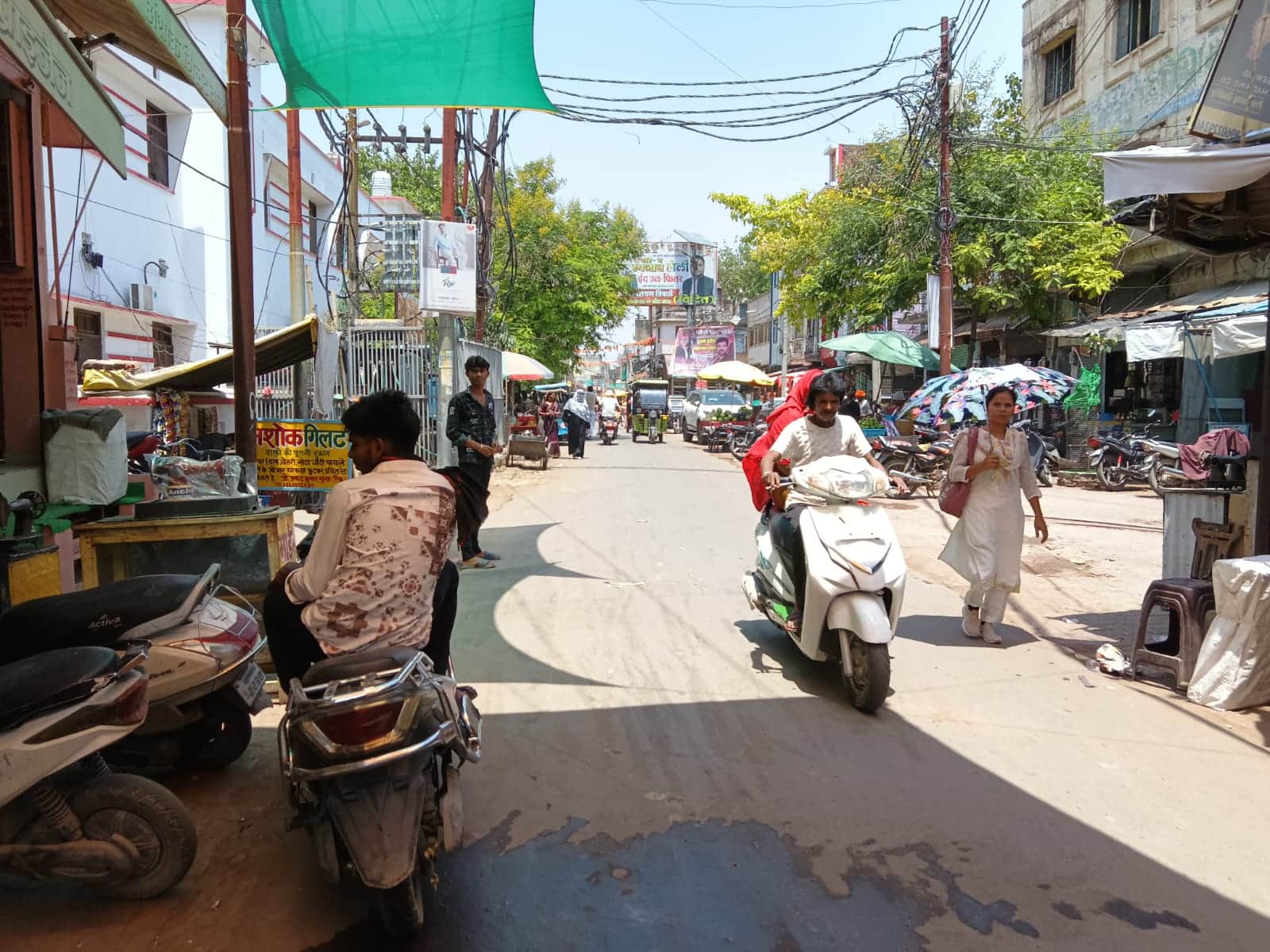 फोटो- 16 शहर के कोतवाली रोड पर छाता लगाकर निकलतीं युवती। संवाद