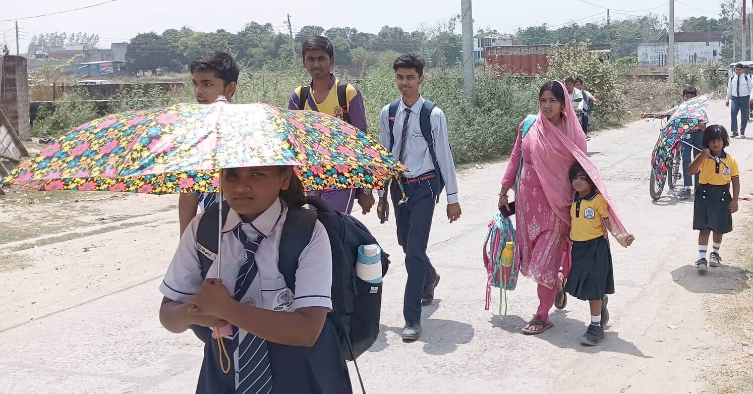 फोटो-18-बलरामपुर में कड़ी धूप से बचने के लिए छाता और दुपट्टा का सहारा लेते विद्यार्थी ।-संवाद