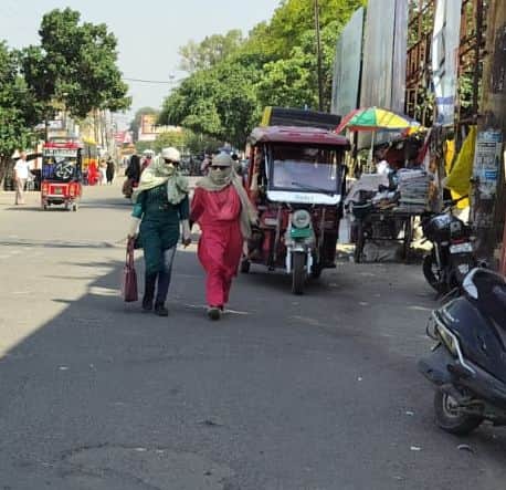 गर्मी में सुरक्षा के लिए मुंह बांधकर जाती महिलाएं। संवाद