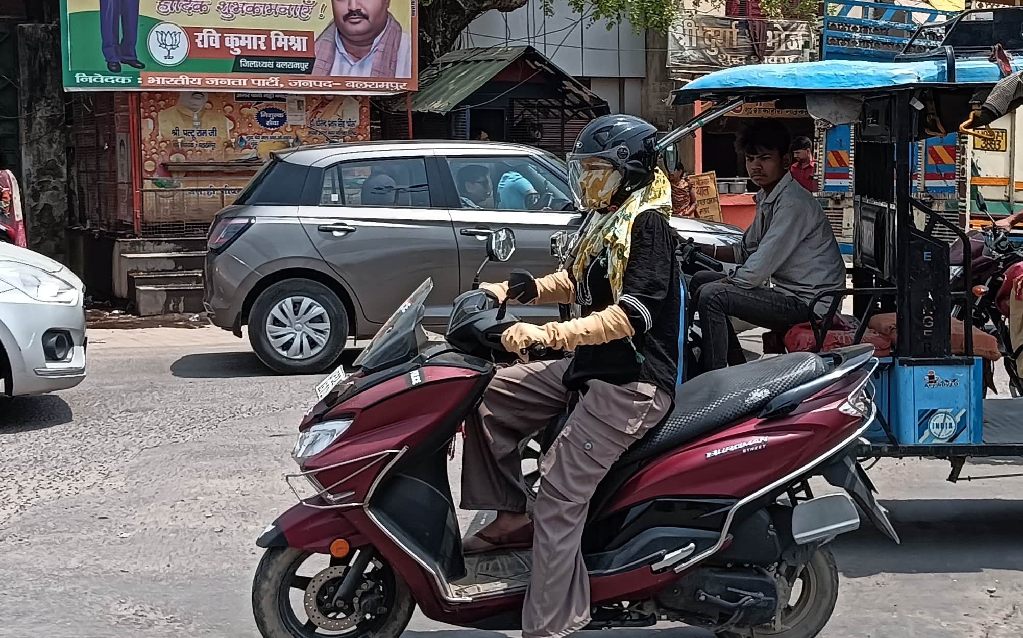 बलरामपुर के वीर विनय चौराहे पर धूप से बचने के लिए दुपट्टे से चेहरे लपेटकर जाती युवती ।-संवाद