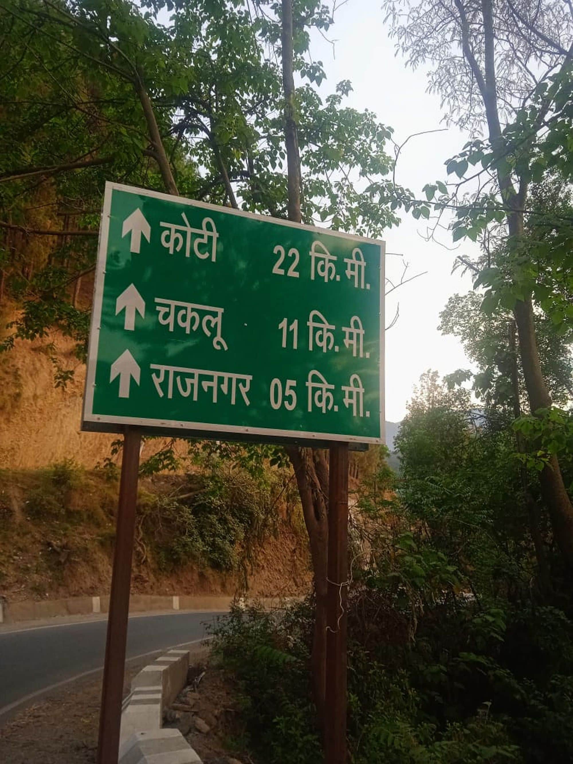 चंबा-तीसा मार्ग पर कियाणी जीरों पॉईंट के पास लगा राजनगर 5 किलोमीटर की दूरी का बोर्ड़।संवाद