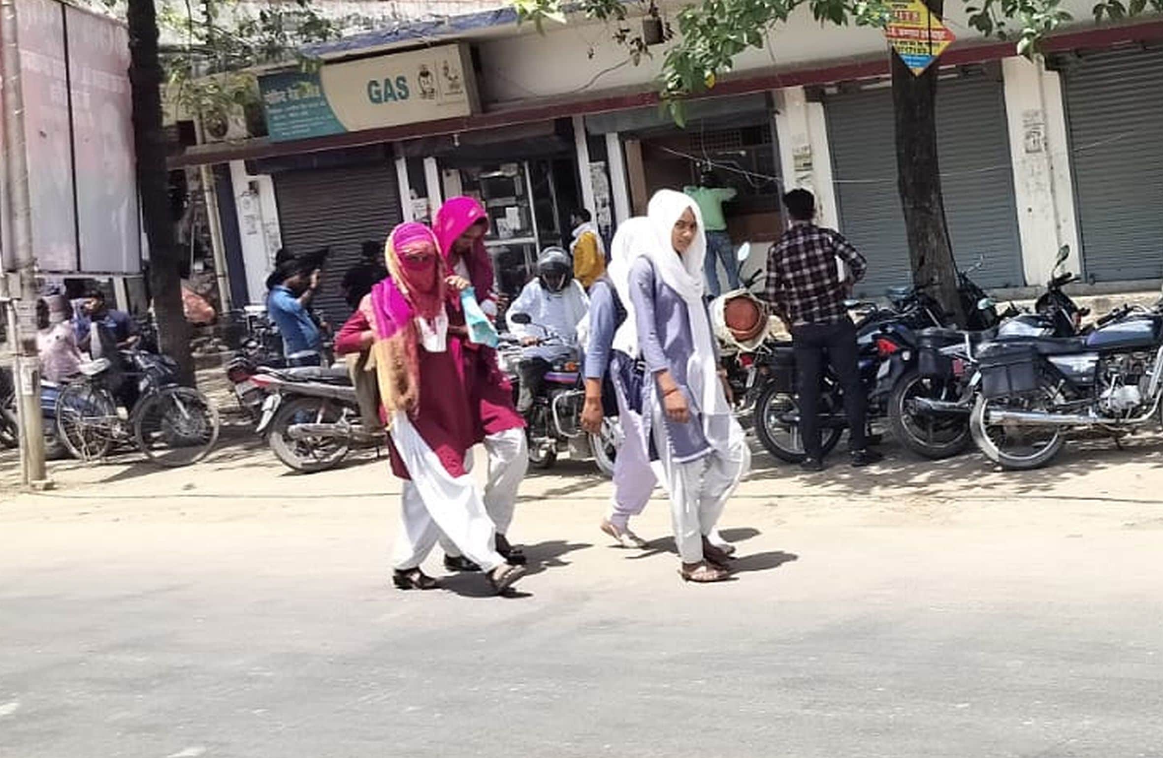 गौरीगंज शहर में धूप से बचाव के लिए सिर ढंककर जाती छात्राएं। -संवाद