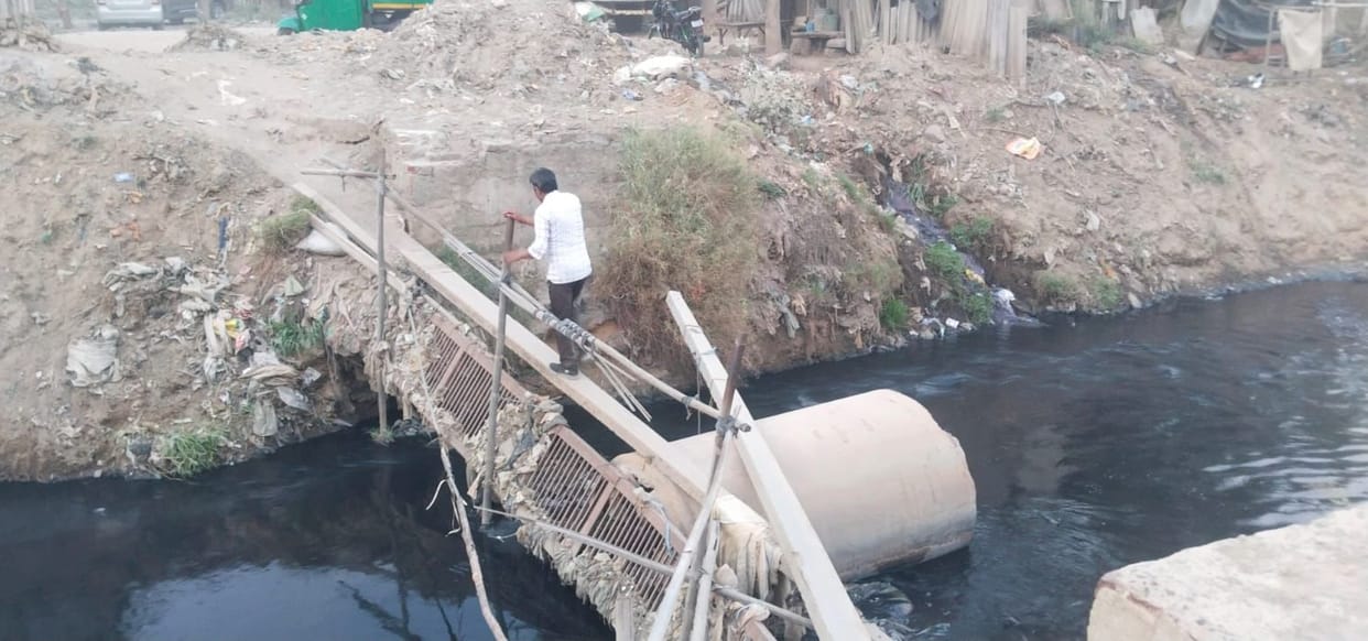 The temporary and dilapidated bridge over the drain is likely to cause accidents.