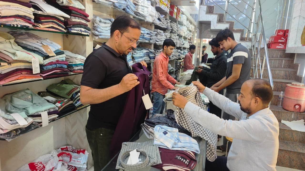 शहर में कपड़े की दुकान पर खरीदारी करते लोग। संवाद