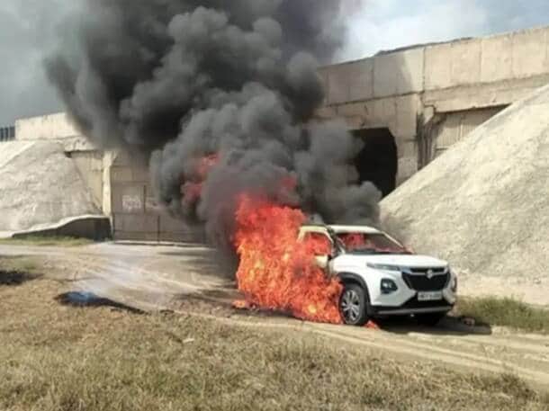 A car parked on a farm road caught fire